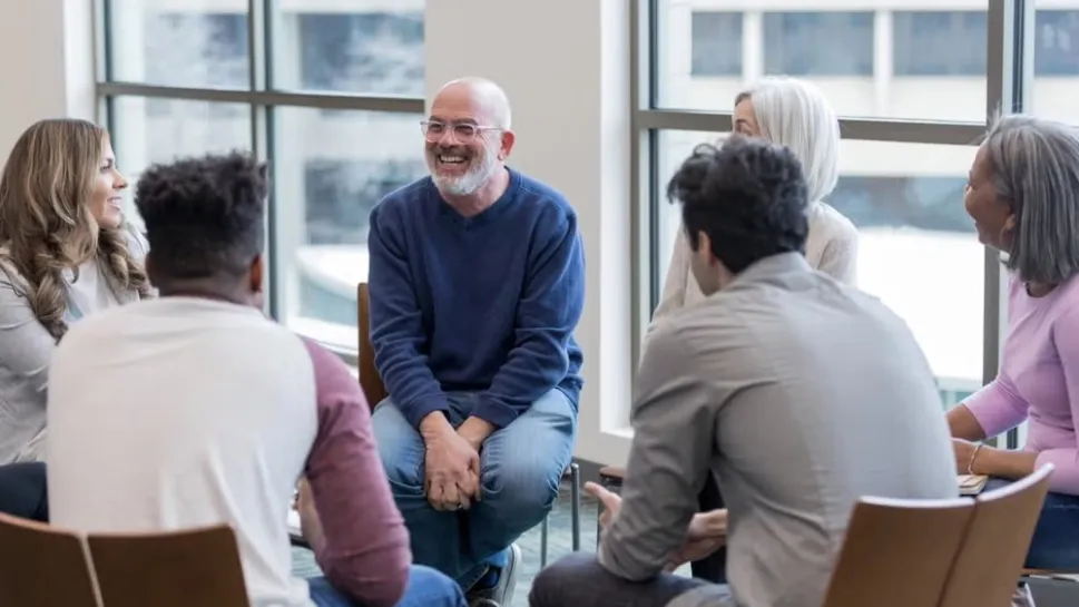 A supportive mental health social worker engages with clients in a professional setting in Australia.