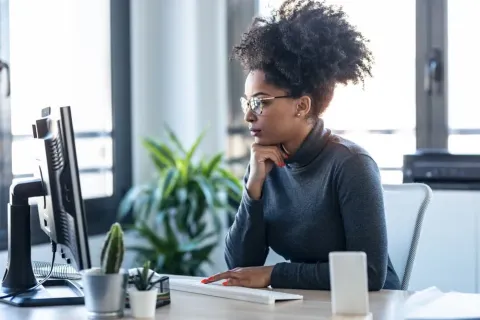 A woman looking at a screen, representing online learning.