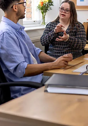 1. A man and woman seated at a table, engaged in conversation over drinks.