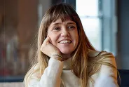 Woman smiling at camera in greenery filled office space