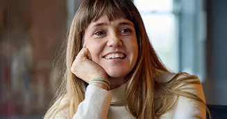 Woman smiling at camera in greenery filled office space
