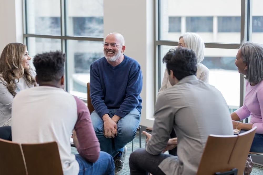 A supportive mental health social worker engages with clients in a professional setting in Australia.
